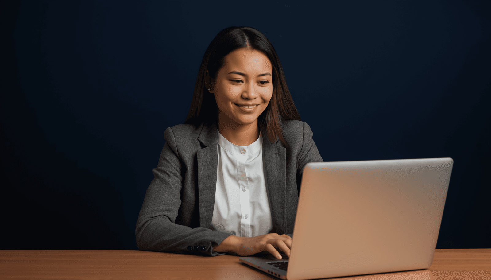 Young Filipino female teacher in blazer using laptop to apply for LET via PRC LERIS Philippines 2026